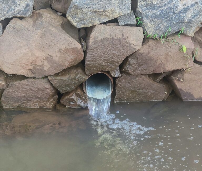 a large pipe is coming out of the water